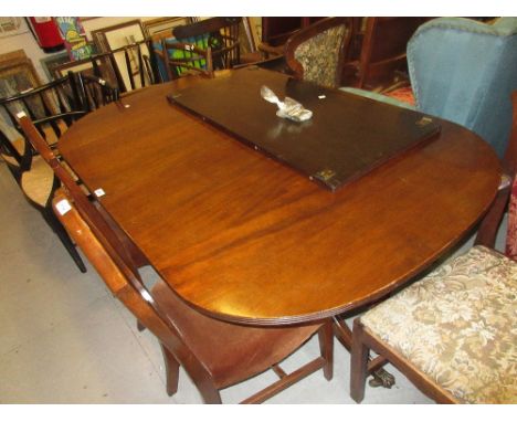 Mahogany twin pedestal dining table with a solid reeded top on turned column supports and tripod bases with brass paw caps an