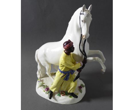 A 19th century hand-decorated Meissen porcelain figure after J J Kändler – rearing grey stallion and groom holding the reins.