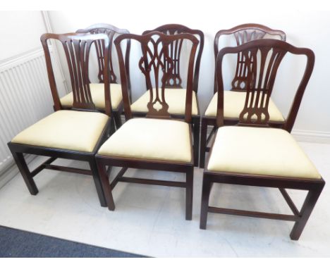 A set of four late 19th century Hepplewhite period mahogany dining chairs having pierced splats and drop-in seats together wi