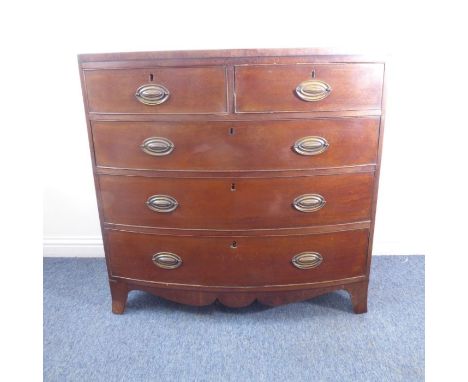 An early 19th century bow-fronted mahogany chest; the caddy-style cross-banded top above two half-width and three full-width 