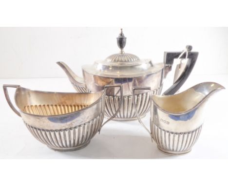 A hallmarked silver three-piece tea service in Georgian style: teapot, two-handled boat-shaped sugar and helmet-shaped cream 