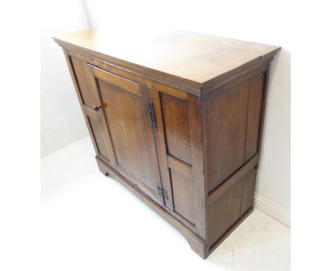 A good oak side cabinet (probably 18th century with restorations); the overhanging top above a single central panelled door w