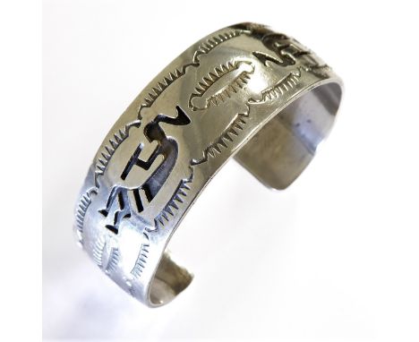 A heavy sterling silver bangle engraved with stylised decoration of figures and shapes (weight approx. 39g)