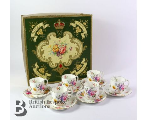 Royal Crown Derby porcelain, comprising six cups and six saucers, hand painted with flowers with gilded handles, housed in th