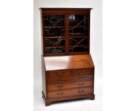 A Victorian mahogany bureau bookcase, the upper section having two astragal glazed doors enclosing four adjustable shelves ab