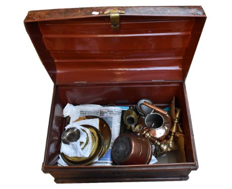 A metal trunk containing brass and copperware including pair of candlesticks, teapot, etc.