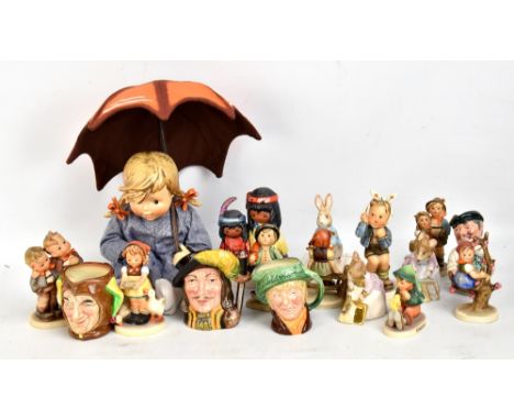 A small group of figurines to include Goebel examples, Royal Doulton character jugs, and a Peter Rabbit figure stood on a boo