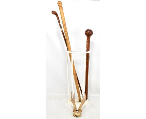 Two walking sticks/canes, a knobkerrie and a small pair of antlers in white painted stick stand.