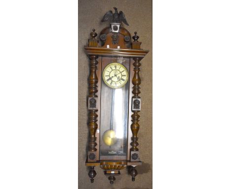 A 19th century Vienna wall clock, having eagle finial above circular dial set with Roman numerals and subsidiary seconds dial