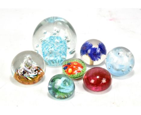 A group of seven paperweights to include a Caithness 'Myriad', and a Caithness 'Pebble', a resin example, etc (7).