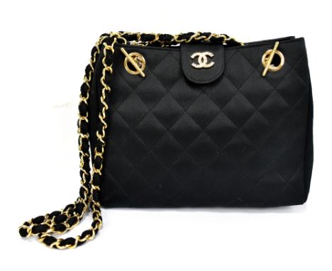 CHANEL; a black satin quilted evening bag featuring a fabric and gold chained shoulder strap and a gold and diamanté Chanel '