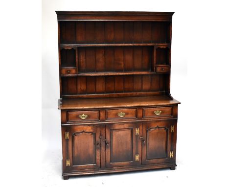 An oak dresser with two shelf boarded plate rack above arrangement of three short drawers and three cupboard doors, 187 x 138