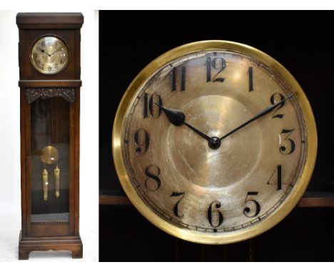 An early 20th century caved oak longcase clock with silvered brass dial having Arabic numerals above large glazed door raised