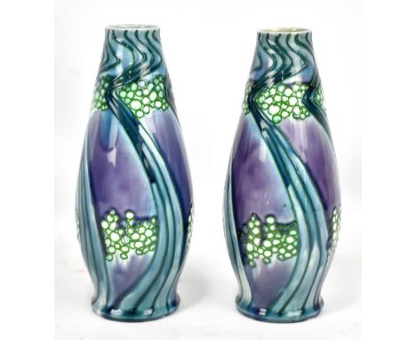 MINTON; a pair of Secessionist range vases of ovoid cylindrical form with relief decoration of circles and stylised linear mo