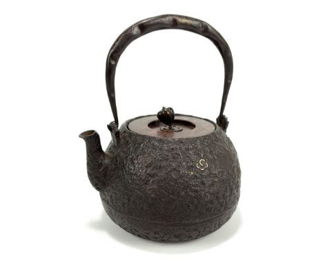 A good 17th/18th century Japanese cast iron spirit teapot with swing loop handle, circular lid with bud finial, textured body