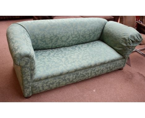 A Victorian green upholstered drop-end sofa on bun feet.