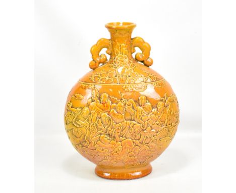 A large Chinese yellow/orange glazed twin handled moon flask, decorated with seventeen Buddhist Immortals and dragon amongst 