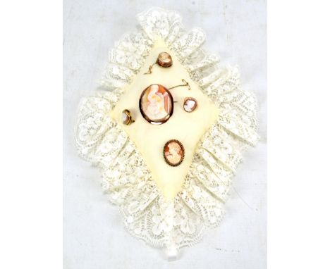 Four carved cameo brooches, the largest featuring woman playing harp in yellow metal mount stamped 9ct with the three smaller