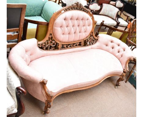 A good 19th century walnut cameo back sofa with carved foliate detail and scroll arms to cabriole legs on castors, in pink fl