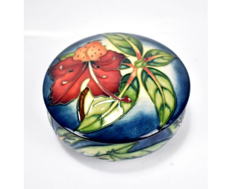 MOORCROFT; a floral tubeline decorated lidded bowl on blue ground, impressed marks and year cipher for 2002 to base, diameter