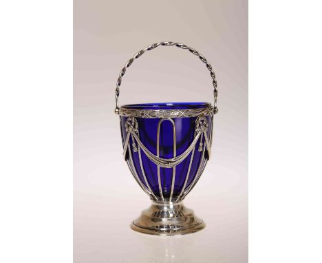 AN EDWARDIAN SILVER SUGAR BASKET, Haseler Brothers, Chester 1908, with swing handle and blue glass liner. 9cm excluding handl