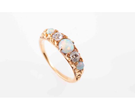 A LATE VICTORIAN OPAL AND DIAMOND RING, the three circular cabochon-cut opals spaced by pairs of old brilliant-cut diamonds s