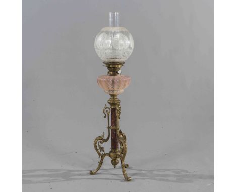 A VICTORIAN GILT BRASS, MARBLE AND GLASS OIL LAMP, with tinted writhen reservoir and raised on acanthus cast out-scrolled fee