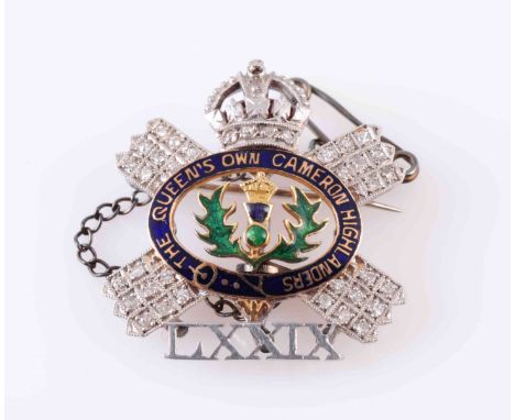 A DIAMOND AND ENAMEL BROOCH, set to the inside with a blue and green enamel thistle emblem, within a surround of blue enamell