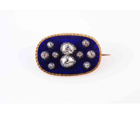 A GEORGIAN ENAMEL AND DIAMOND BROOCH, CIRCA 1800-20, the oval plaque of dark blue guilloche enamel set to the centre with two