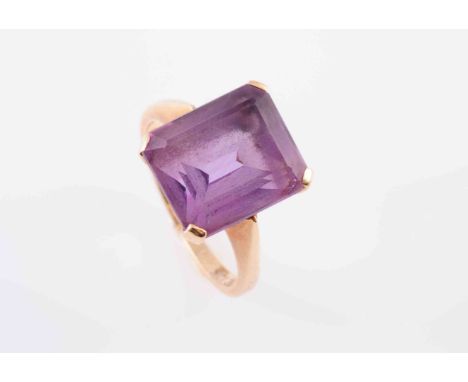 AN AMETHYST RING, the square cut amethyst four claw set in an open pierced detail mount between solid tapering shoulders on a