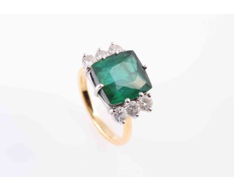 A TOURMALINE AND DIAMOND RING, the square cushion cut green tourmaline six claw set between six brilliant cut claw set diamon