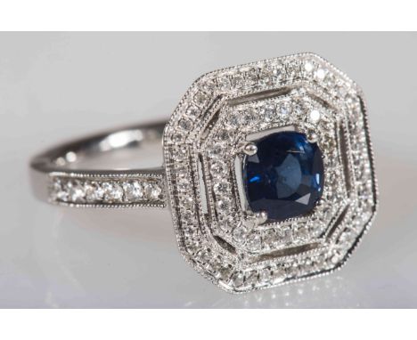 A SAPPHIRE AND DIAMOND RING, the cushion mixed cut sapphire four claw set within an inner surround of brilliant cut claw set 