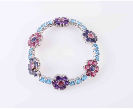 AN AMETHYST, TOURMALINE AND TOPAZ BRACELET, the six flower heads set with either circular mixed-cut amethysts or tourmalines 