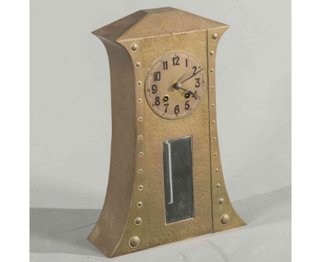 A CONTINENTAL ARTS AND CRAFTS HAMMERED BRASS MANTEL CLOCK, the tall case decorated with bosses, two-train movement. 38cm