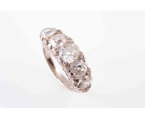 A LATE VICTORIAN FIVE STONE DIAMOND RING, CIRCA 1890, the graduating row of old brilliant-cut diamonds set within a pierced s