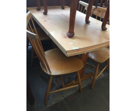 A WOOD EFFECT DRAWER LEAF TABLE AND FOUR LIGHT WOOD SPINDLE BACK CHAIRS