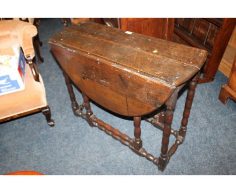 AN EARLY 19TH CENTURY OAK DROPLEAF TABLE WITH BOBBIN TURNED SUPPORTS