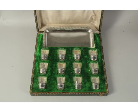 TASSILLY BOIVIN, PARIS. A SET OF TWELVE GLASS VODKA TOTS with silver bases and tray, in a fitted case.