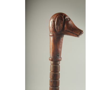 A NAIVE FOLK ART DOG'S HEAD WALKING STICK. 34ins long.