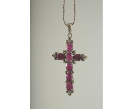 A SILVER AND RUBY SET CROSS on a chain, boxed.