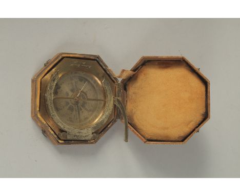 A GEORGIAN OCTAGONAL BRASS TRAVELLING COMPASS with silvered dial. Made in Paris. 3.75ins in a leather travelling case.