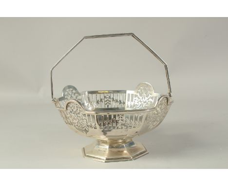 AN OCTAGONAL PIERCED SILVER BASKET with swing handle. Sheffield, 1910.  Maker R &amp; B, weight 18ozs.