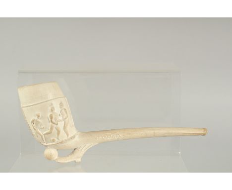 AN EARLY CLAY PIPE depicting footballers. 8.5ins long.