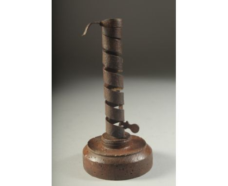AN EARLY WOODEN AND METAL CANDLESTICK. 8ins high.