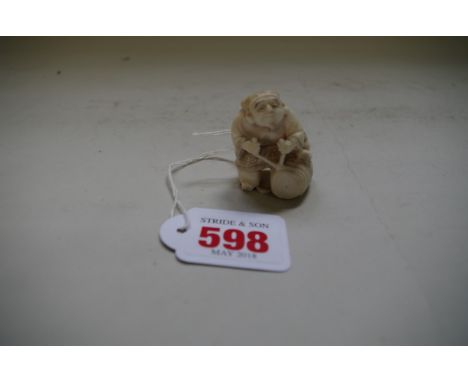 A Japanese carved ivory netsuke, of a man with a rope tied bundle, 4.2cm high. 