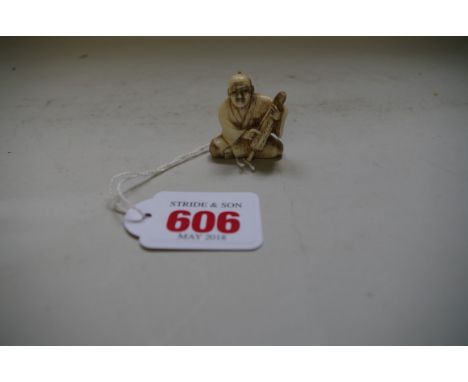 A Japanese carved ivory netsuke of a seated man with a folded parasol,&nbsp;Meiji period,&nbsp;signed, 2.1cm high. 