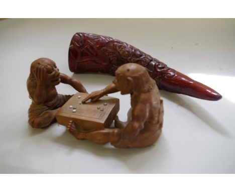 An Oriental carved boxwood group of two figures playing go,&nbsp;14cm wide; together with a relief carved horn. (2) 