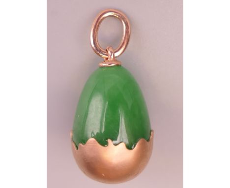 A Russian 14 ct gold jade egg formed pendant.  2 cm high.