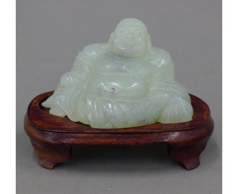 A jade model of Buddha on a wooden stand. 6.5 cm high overall.