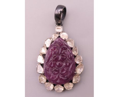 A carved ruby and diamond set pendant.  3.5 cm high excluding suspension loop.